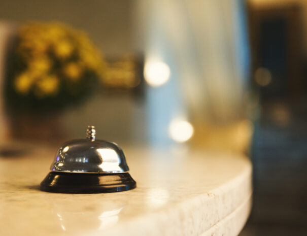 Hotel accommodation call bell on reception desk, contemporary interior, copy space